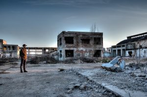Zerfallene Gebaeude mit Mensch im Vordergrund